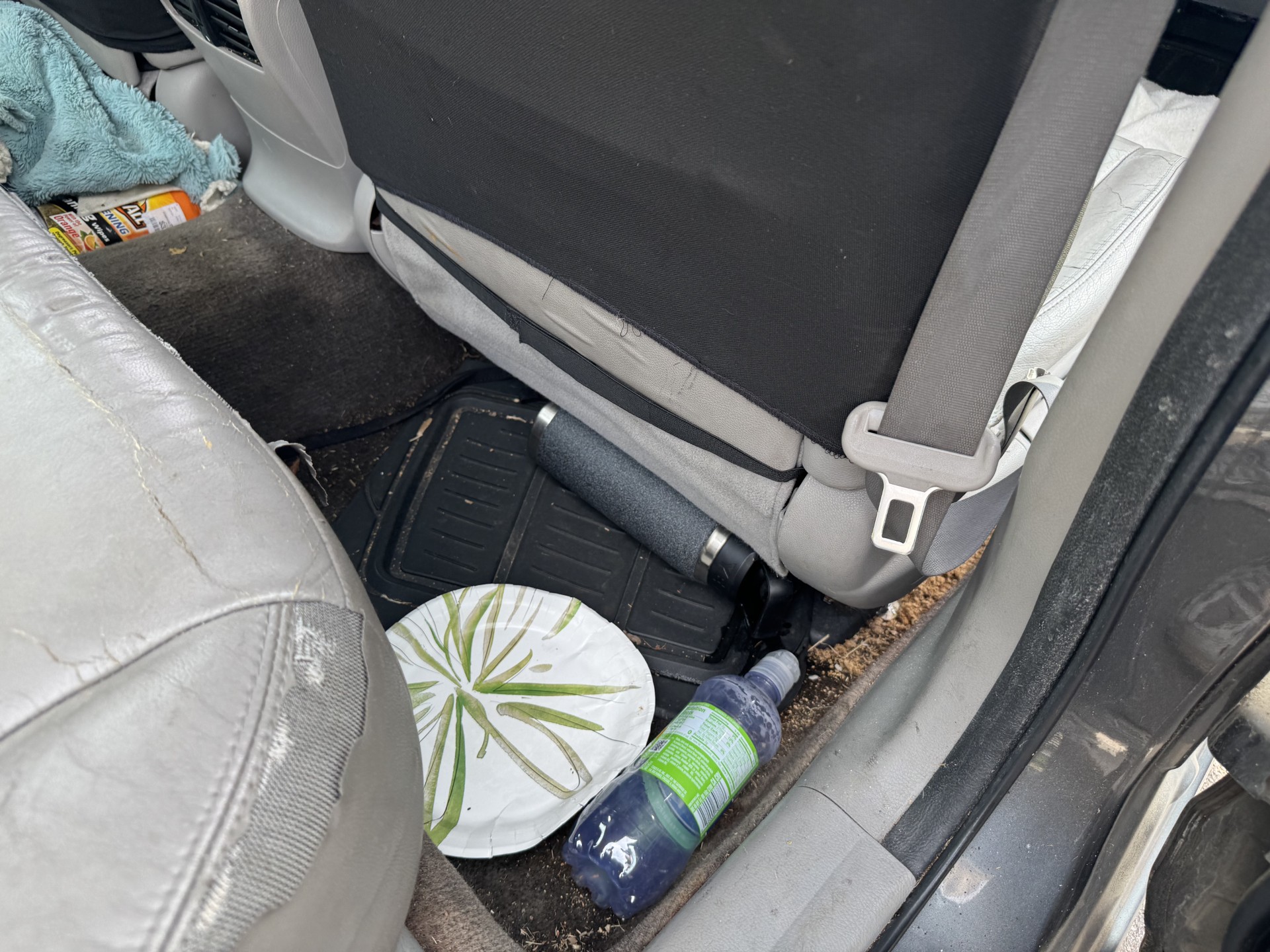 Honda Accord rear passenger floor with trash and debris before cleaning