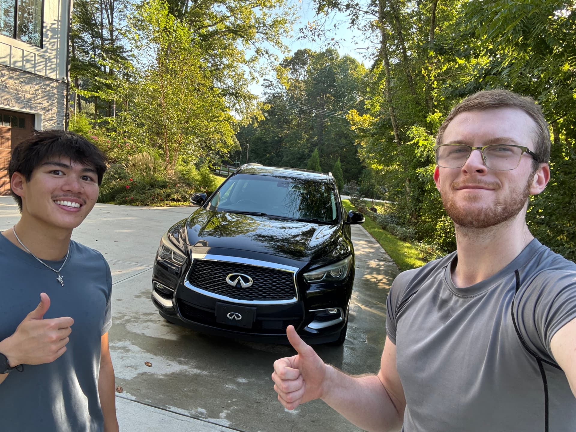 Landon and Ian of The Detailing Drop beside a freshly detailed black Infiniti QX60