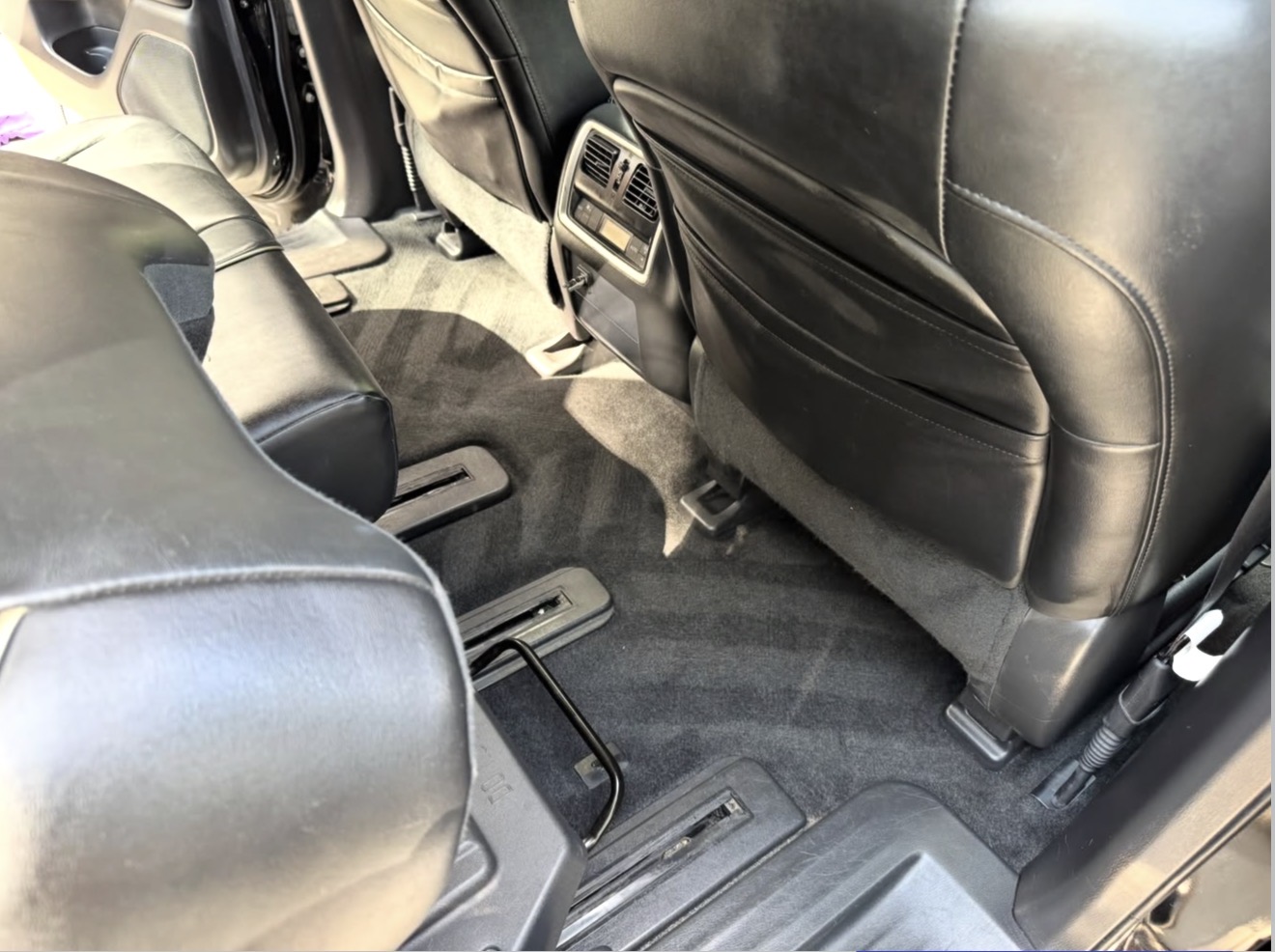 Infiniti QX60 second-row carpet and seat rails vacuumed and shampooed