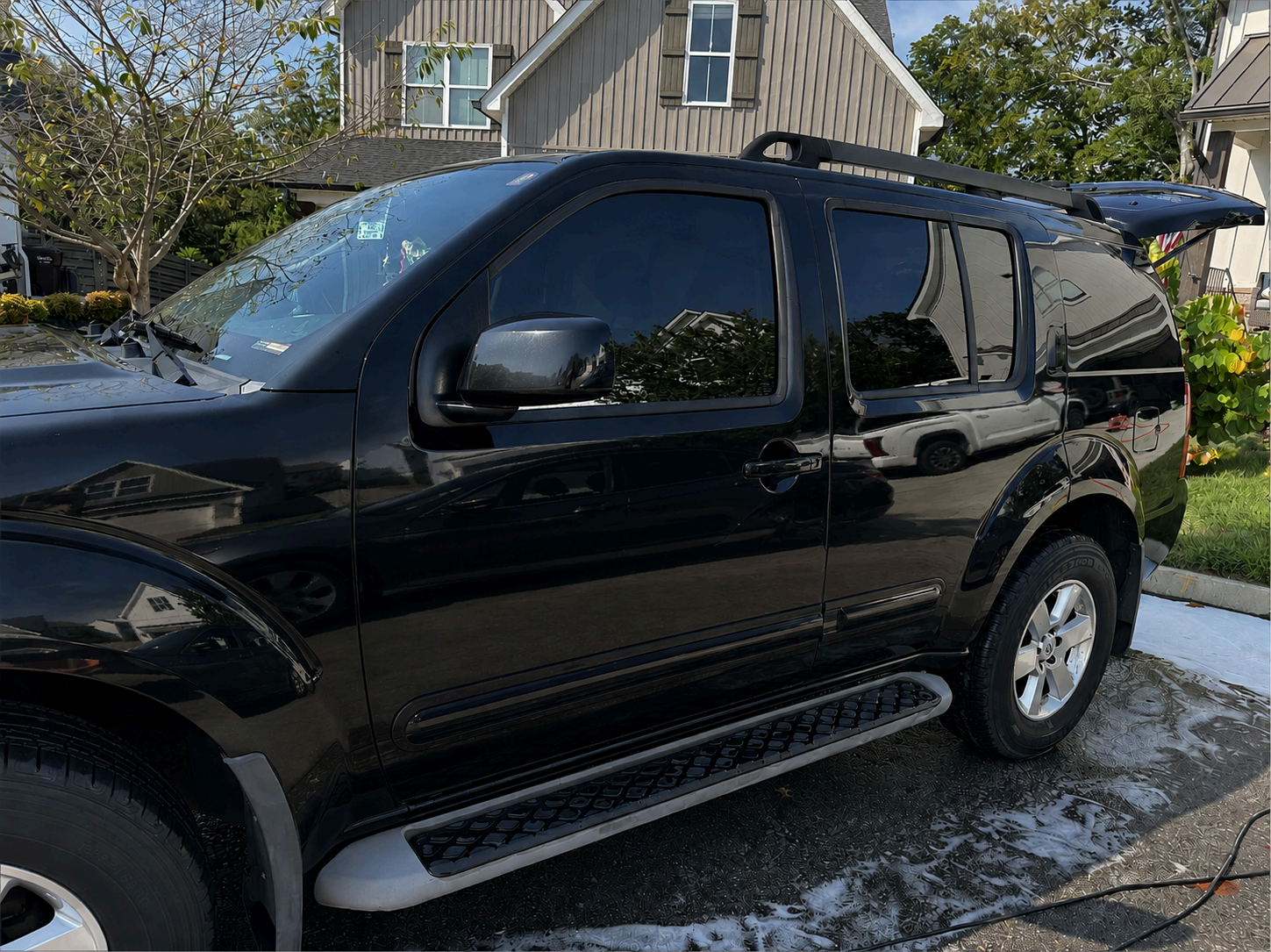 Black Nissan Pathfinder gleaming after a full contact wash