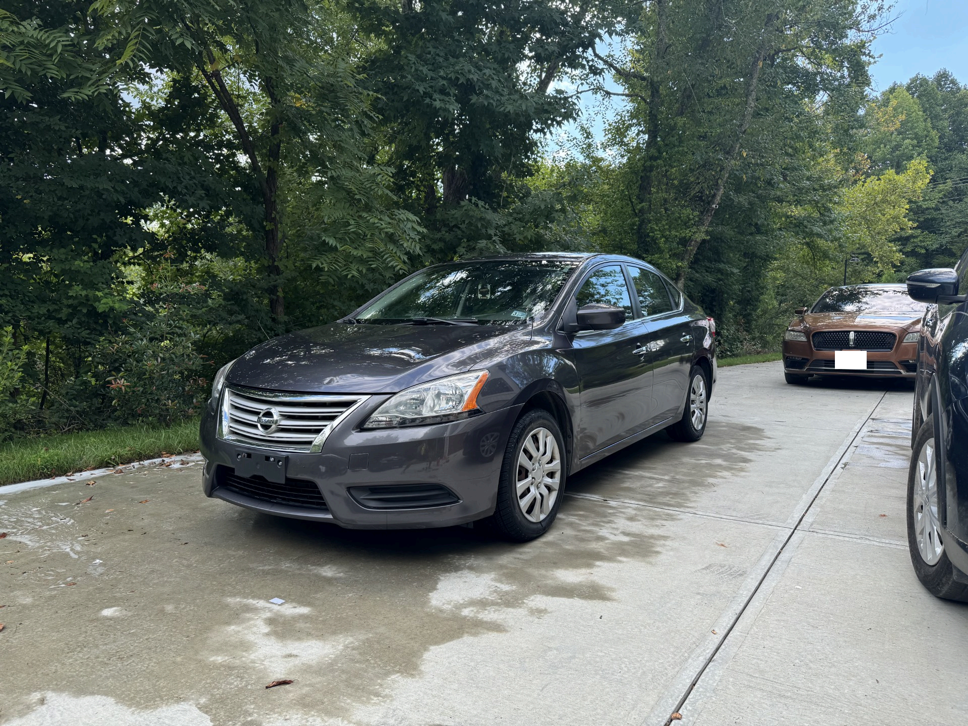 Grey Nissan Sentra parked in a driveway after detailing